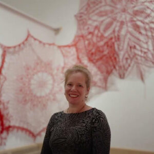 Artist Ashley V. Blalock in front of her crochet installation