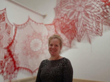 Artist Ashley V. Blalock in front of her crochet installation