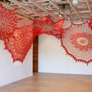 Red-colored crochet installation in an art gallery by Ashley V. Blalock