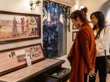Guests reading museum displays about Native Americans at Casa Romantica at sunset